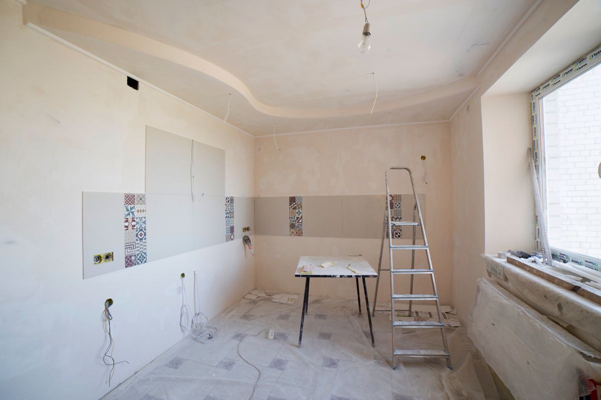 Kitchen midway through renovation, with new plaster and wall tiles