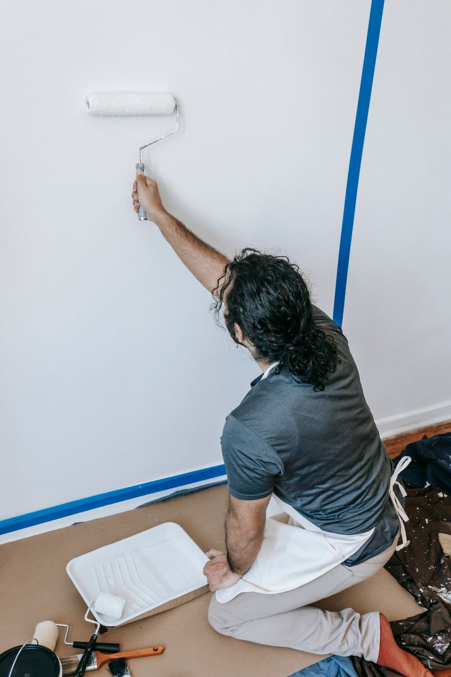 Painter applying a fresh coat of paint to an interior wall